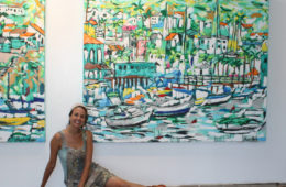 artist Brooke Harker being a mermaid next to paintings