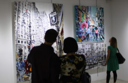 couple viewing original paintings by Brooke Harker