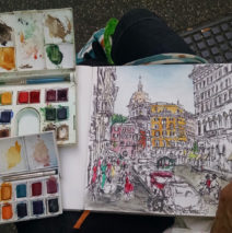 art supplies with a watercolor sketch of Rome, Italy