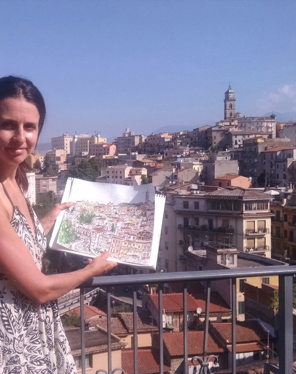 artist Brooke Harker with watercolor of Frosinone, Italy